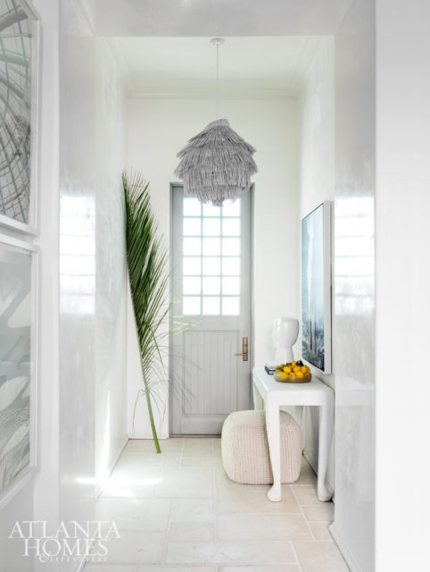 The chandelier in the entryway is made from a basket Turner found in Bali. The console is Mr Brown London and the accessories are Global Views.