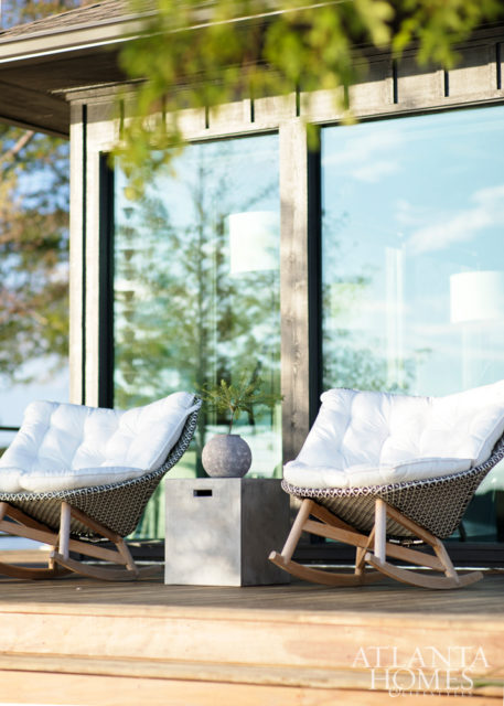 Outdoor rooms feature the same comforts as indoor living spaces. The lining of the new infinity pool was designed and colored so that its reflection would mimic the surrounding lake water. Chaises and umbrellas, RH. Lanterns, Dixon Rye.