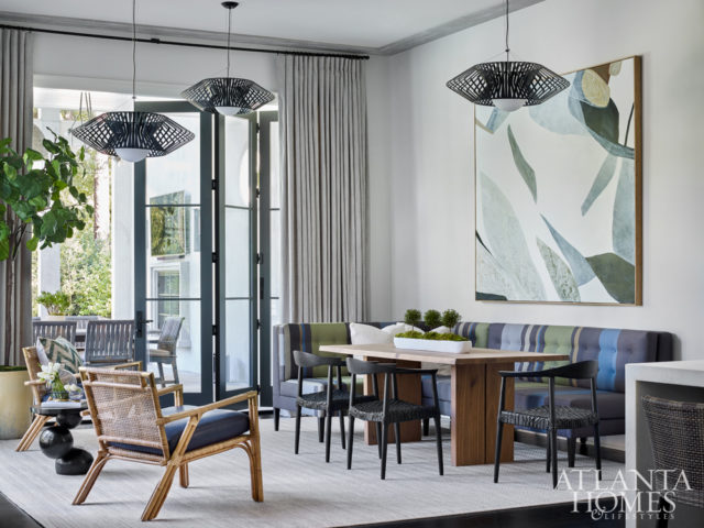 In the breakfast area, a custom banquette by Bjork Studio features “Big Stripe,” a fabric designed by fashion icon Paul Smith in collaboration with textile studio Maharam. Rattan chairs from Serena & Lily exude an organic, coastal feel. The light fixtures are by Possini Euro from Lightology and the art is by Vesela Baker.
