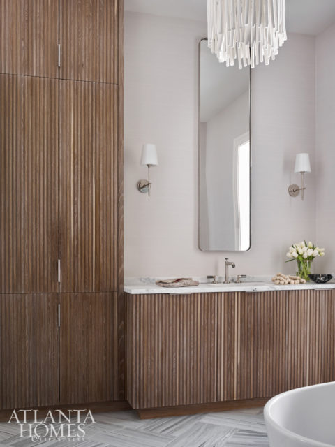 The spa-like master bath combines clean lines and natural materials. The whitewashed light pendant is by Arteriors.