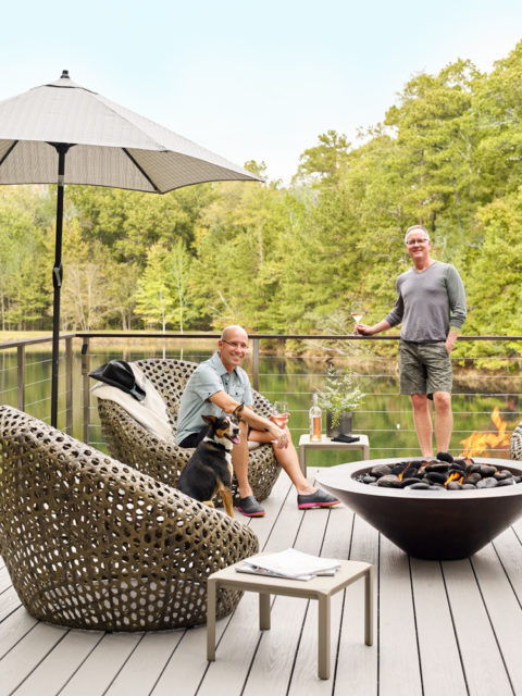 Quinn, seated, and Parrish, enjoy the lakeside firepit with their rescue dog, Izzy.