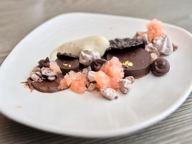 Chocolate ganache tart with chocolate whipped cream, raspberry jam, chocolate sorbet and mendiant by pastry chef Kendall Baez at AIX.