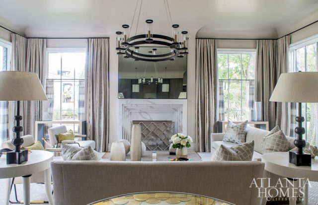 An intimate seating arrangement centered around the fireplace allows the homeowners to spend time with their three grown children in the living room. A Zimmer + Rohde drapery fabric adds softness. The sofas are Hickory Chair, the chairs are Duistt and the iron chandelier is Paul Ferrante through Ainsworth-Noah.