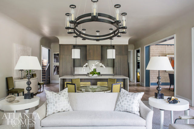 Savage took color cues from the tones of wood in the kitchen when designing the home’s adjacent living room. A Niermann Weeks breakfast table strategically placed between the living and dining spaces pulls double duty as a chic entry hall table. Savage sourced the Adnet dining chairs on a trip to France, and the bar stools are Century Furniture.