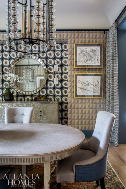 The dining room, which Savage previously designed when the residence played host to the O’More College of Design’s 2017 Show House, is a dramatic departure from its original incarnation. Now, a coffered wood Phillip Jeffries wallcovering adds texture to the walls, while Hermès’ Dune wallpaper adds a gauche effect to a niche. The table is from the homeowners’ own collection, and the drapery is Seemakrish through Paul+. The chandeliers are Paul Ferrante through Ainsworth-Noah.