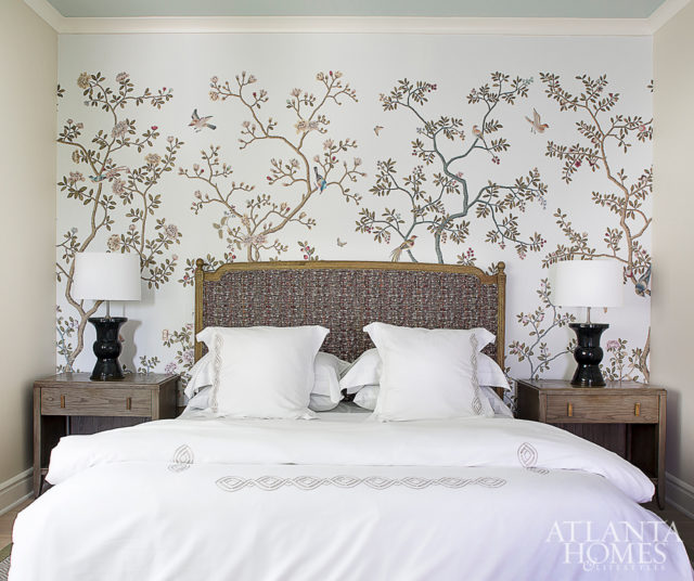 A cherry blossom wallpaper by Fromental through Holland & Sherry infuses natural beauty into a guest room. The lamps are John Boone.