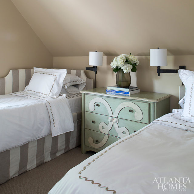 Part of the new addition above the garage, this guest suite features a pair of twin beds by Suzanne Kasler for Ballard Designs and bedding by Yves Delorme. The guest bathroom features sconces from Waterworks and a Cambria quartz vanity.