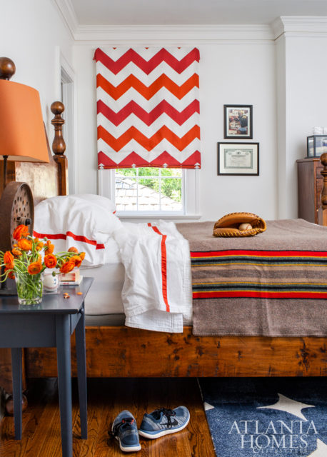 This teen bedroom nods to the family’s love of sports, featuring signed memorabilia and a playful red-and-blue palette. The drapery fabric is Schumacher and the bedding is Peacock Alley.