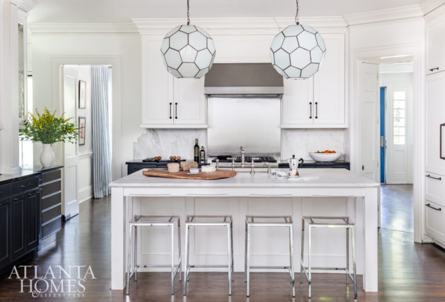 The kitchen is “headquarters of the house,” Kleinhelter says, so it needed to be both functional and streamlined. She eliminated ornate hardware on some of the room’s nonfunctioning cabinetry, painting lower cabinets Benjamin Moore’s Polo Blue to tie in with the rest of the home. The light fixtures are through Pieces.
