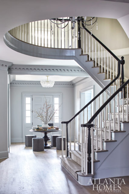 An oak foyer table and stools covered in durable stain-resistant fabric offers a spot to visit with impromptu guests. The light fixture is from West Elm.