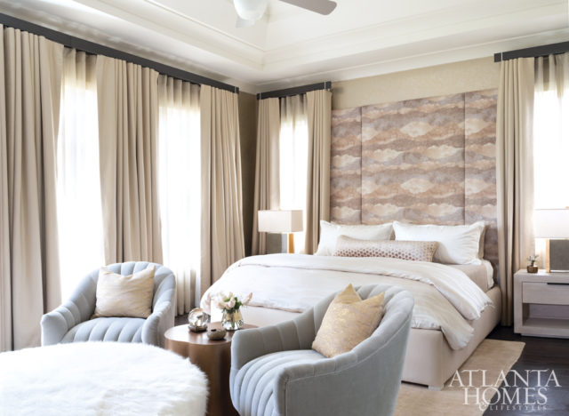 In the master bedroom, a wallcovering by Phillip Jeffries, draperies by Pindler and sheers by JF Fabrics create an enveloping retreat. The plush swivel chairs are from Arteriors.