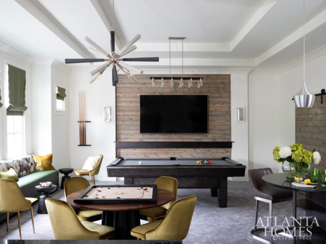 The floral fabric by Romo on the custom banquette coordinates with the shades by Robert Allen and the green velvet chairs from Zuo in the second-floor recreation room. The game table is from CB2.