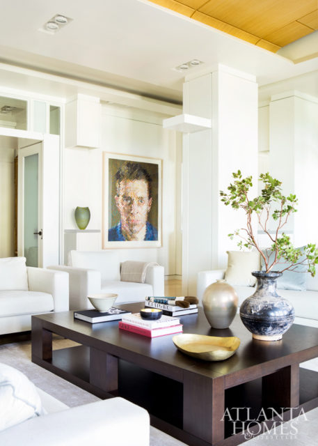 A large cocktail table by Christian Liaigre is an ideal spot to display collections. The portrait is by Chuck Close through Alan Avery Art.