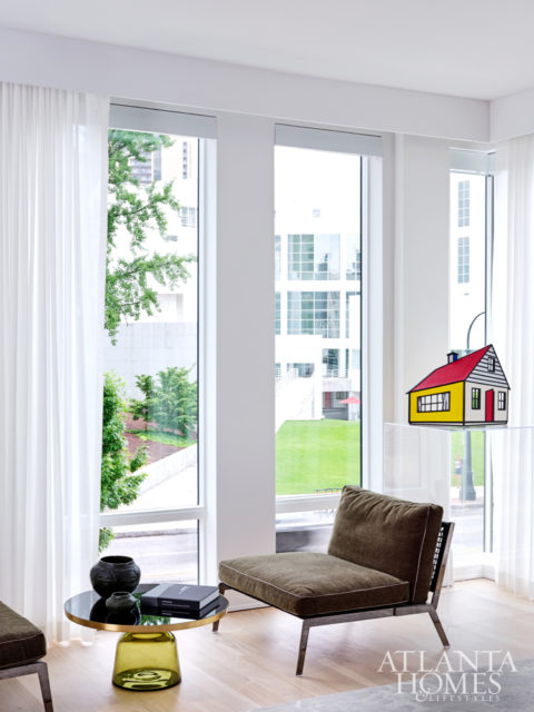 Roy Lichtenstein’s House III maquette, perched atop a custom acrylic pedestal, is given pride of place in a living room corner; the actual sculpture, which sits on the High’s front lawn, is visible from this vantage.