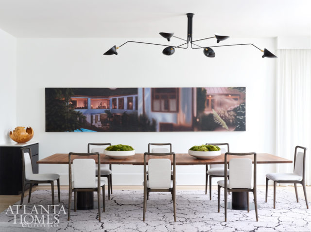The custom dining table by Skylar Morgan Furniture can be reconfigured into three small tables or remain one large banquet table to accommodate a crowd. A hyperrealist painting by Damian Loeb is a conversation starter.