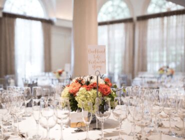 Formal dining table setting with floral centerpiece and place cards.