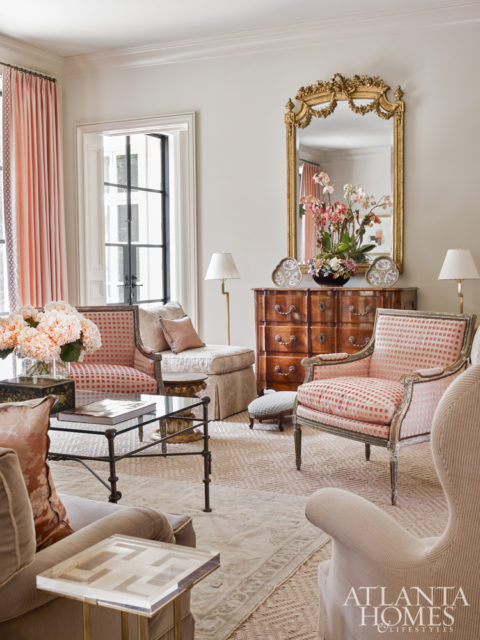 An Oushak rug layered atop a large sisal fosters an intimate feeling in the formal living room, which features a mix of antiques alongside new pieces, such as a brass table with a Lucite top by Lucy Smith through Holland MacRae.