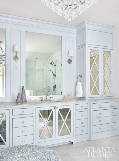 Like the adjacent closet, the master bathroom boasts custom cabinetry by Phoenix Millworks with antiqued mirror and a chandelier from Crystorama.