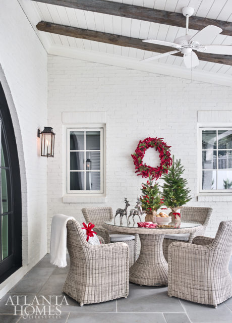 Outfitted with bluestone flooring and a painted tongue-and-groove ceiling with rustic beams, the patio, which overlooks a generous, flat yard, feels almost beachy. The dining table and chairs are by Kingsley Bate.