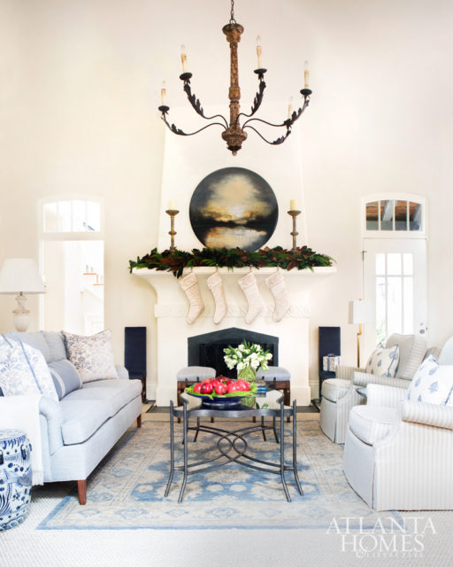 An Oushak rug from Moattar rests above a sisal Stark rug. The sofa, chairs and small fireplace benches are covered in an Elizabeth Eakins fabric through R Hughes. The chair pillows are Zimmer + Rohde through Ainsworth-Noah. The cream stockings and acrylic stocking holders are from Fig & Dove.