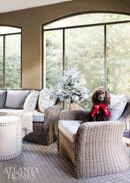 The screened-in porch features a Kingsley Bate sofa and chair, upholstered in Perennials and Link Outdoor, respectively.