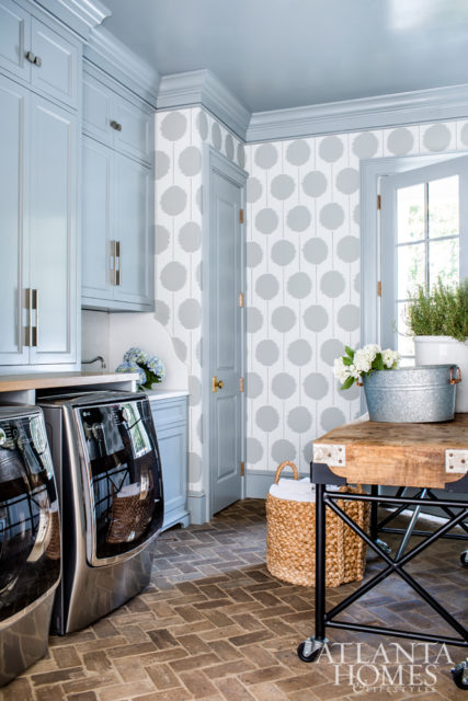 A graphic Scion wallcovering adds a dose of whimsy to the laundry room; the custom folding table was made from a large butcher block Gilbreath found in France.