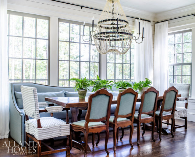 Designed to accommodate large groups, the breakfast room features a mix of seating options. The antique walnut table is from Belgium and the light fixture is by Noir.