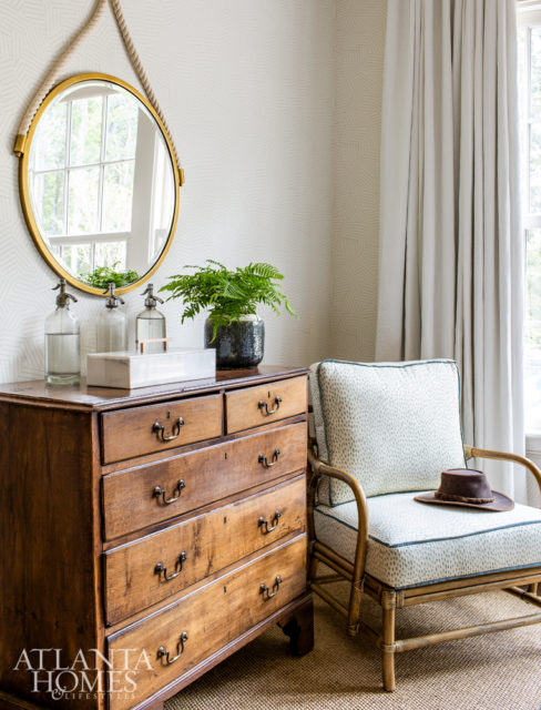 In the guest bedroom, an antique chest purchased in Belgium sits beside a chair from Selamat Designs covered in a playful fabric by Erika M. Powell Textiles.