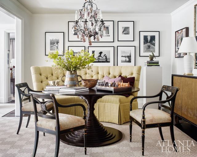 An artful Hélène Aumont table through R Hughes commands the dining room. Its striking lines are softened by a custom Bungalow Classic banquette and the homeowners’ own Regency-style chairs. The gallery wall features black-and-white photography by Henri Cartier-Bresson and Édouard Boubat.
