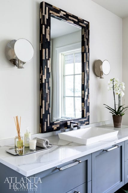 Modern bathroom vanity with gray cabinets, white quartz countertop, rectangular vessel sink, and a mosaic wood-framed mirror.