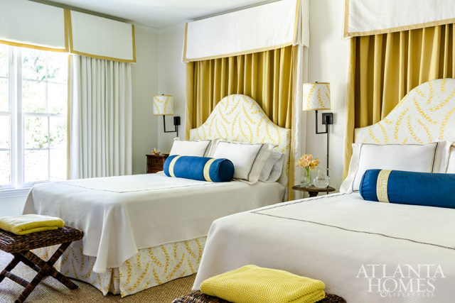 Pelmets above the beds and window provide architectural detailing in the guest bedroom, where a set of asparagus plates hangs over a French chest, a treasured family antique.