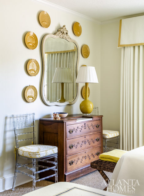 Pelmets above the beds and window provide architectural detailing in the guest bedroom, where a set of asparagus plates hangs over a French chest, a treasured family antique.