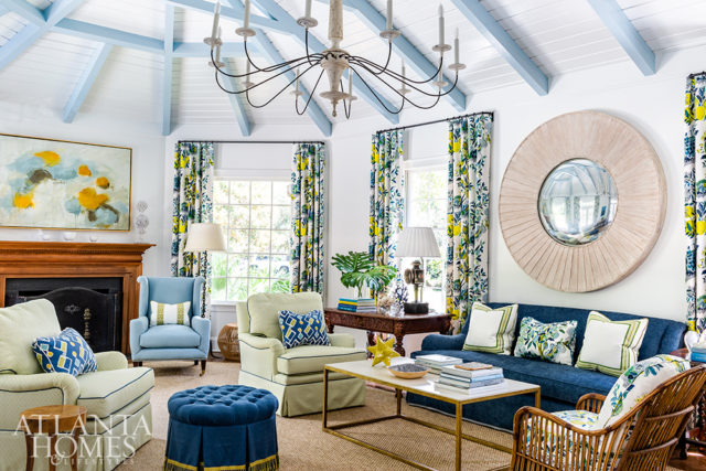 The original beamed ceilings were painted to lighten the space, while a mix of bold colors add vibrancy. Citrus hues mix with hints of ocean blues in the Schumacher drapery fabric that frames the great room.