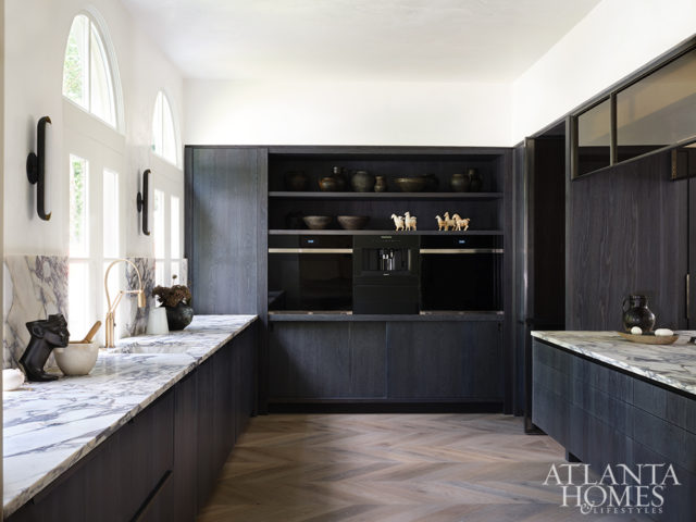 Karpaty Cabinets’ cabinetry was crafted from white oak and given a custom inky finish, lending the kitchen a sleek, modern verve. The cabinetry conceals a walk-in pantry as well as an upright refrigerator, steam oven and wine cooler. The central island is outfitted with a custom integrated fan shrouded in a smoked glass-and-metal cover. Photo by Mali Azima