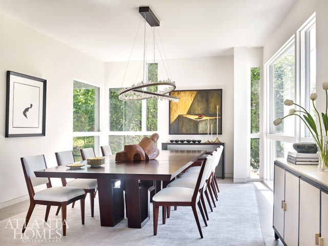 A custom rock crystal chandelier by Christopher Boots from R Hughes illuminates an expandable wooden table by Hellman-Chang in the formal dining room.