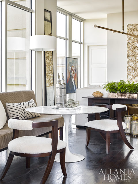 A dining bench and hide-covered chairs surround a white tulip table by Saarinen from Knoll in the dining area. The floor lamp is from CB2.