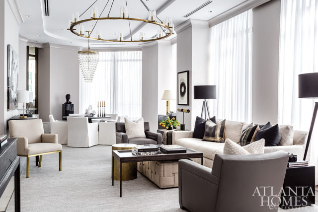 A rug unifies three distinct areas in the living room, which provides room for dining, conversation and work. The tripod lamps are from Townhouse by Robert Brown.