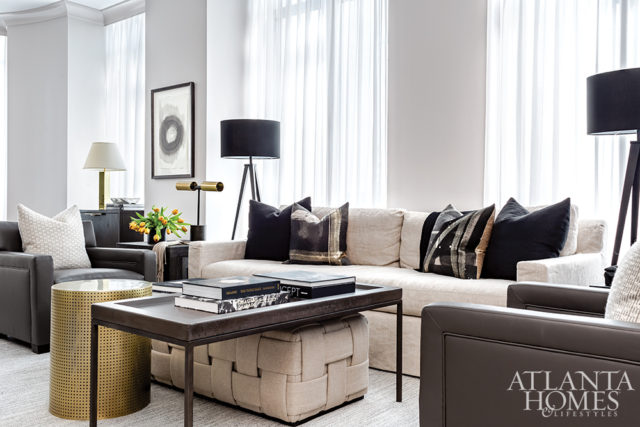 Designer Robert Brown paired a traditional cocktail table from Bradley USA with a braided linen ottoman and a perforated brass side table.