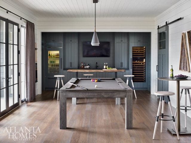 Game room with a grey pool table, built-in bar with dark blue cabinetry, wine fridge, beverage cooler, and wood plank ceiling.