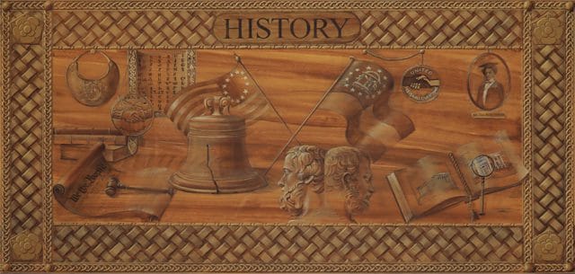 Wood carving depicting historical American symbols including the Liberty Bell, the "We the People" scroll, the Betsy Ross flag, and busts of historical figures under the word "HISTORY".