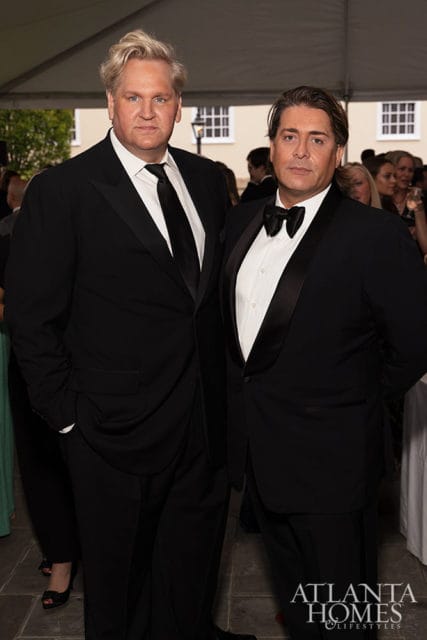 Two men in tuxedos, one with blond hair, the other with dark hair. Atlanta Homes & Lifestyles logo