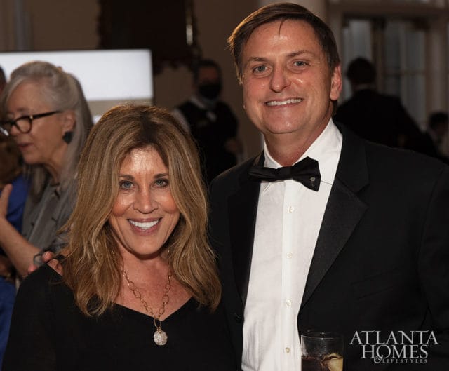 Man in tuxedo and woman in black smiling, Atlanta Homes & Lifestyles logo
