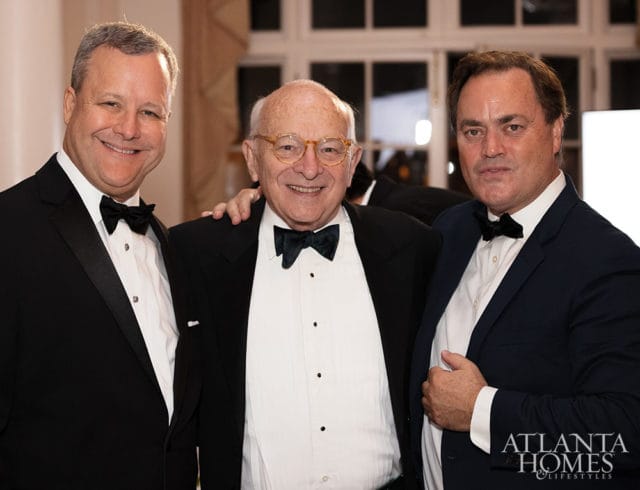 Three men in tuxedos, one with glasses, with Atlanta Homes & Lifestyles logo
