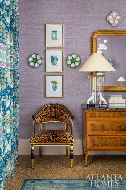 Purple textured wallpaper with framed art, leopard print chair, and wooden dresser