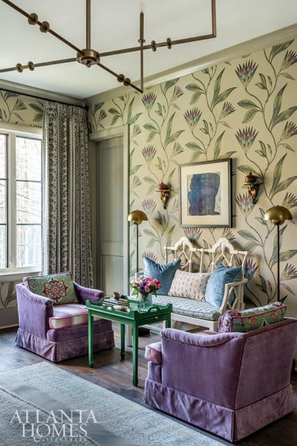 Living room with floral wallpaper, purple velvet chairs, green tray table, and white bench