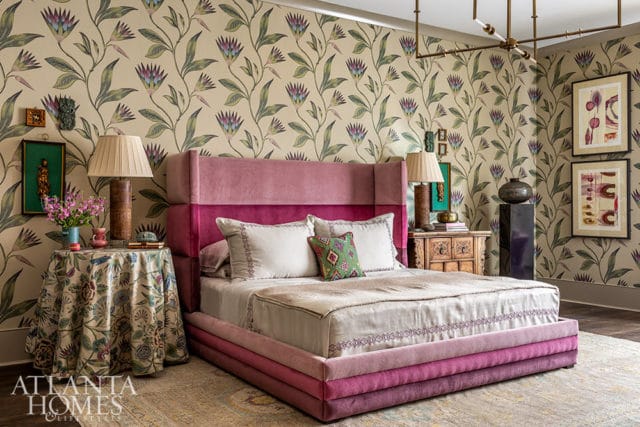 Bedroom with floral wallpaper, pink velvet bed, and ornate nightstand.