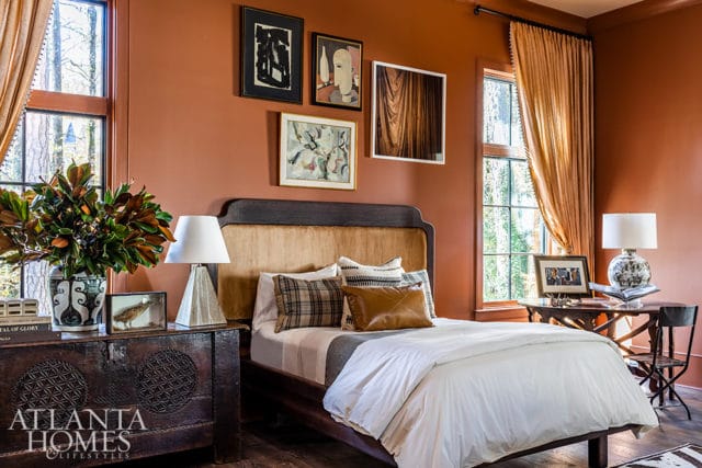 Bedroom with rust-colored walls, a dark wood bed with a tan upholstered headboard, and a dark wood