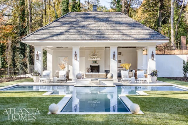 Outdoor living space with pool, covered patio with fireplace, seating, and grill.