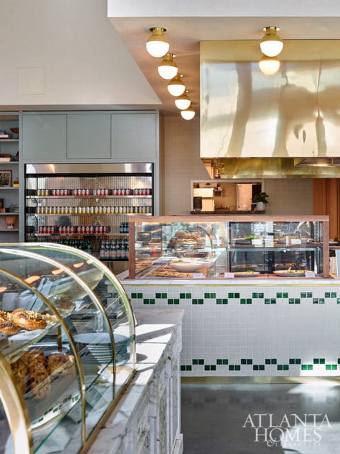 Bakery interior with glass display cases, marble counter, and brass hood.