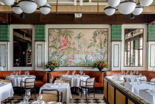 Restaurant dining room with flamingo mural, leather booths, and checkered floor